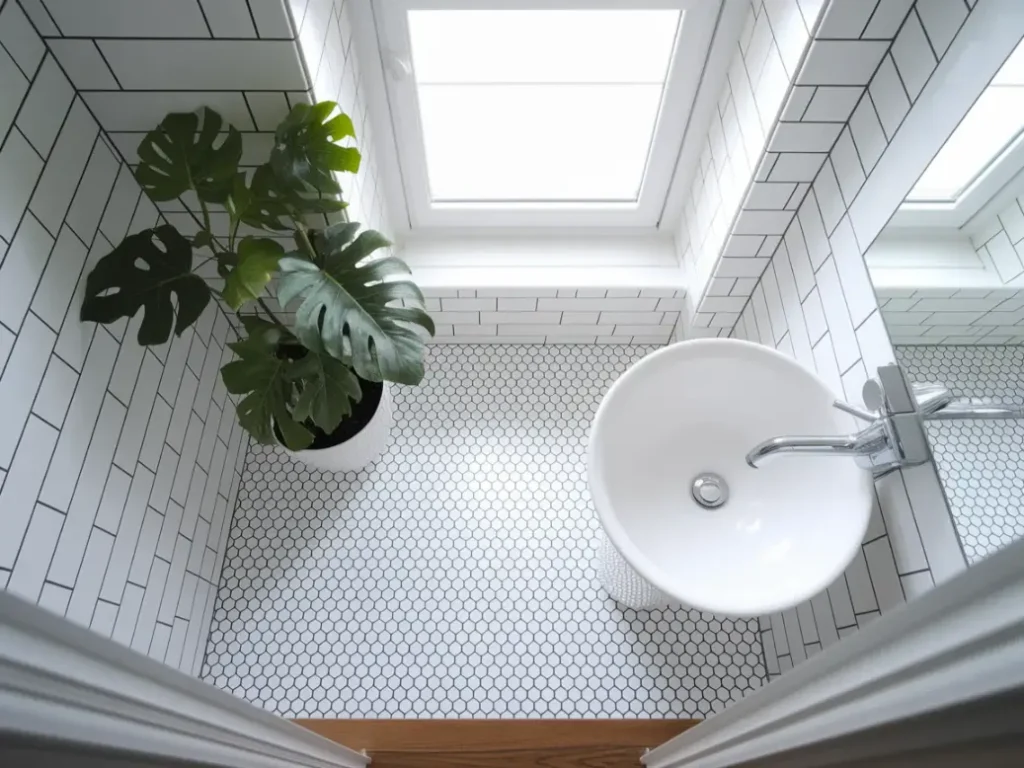 A small bathroom floor with white hexagon peel-and-stick tiles